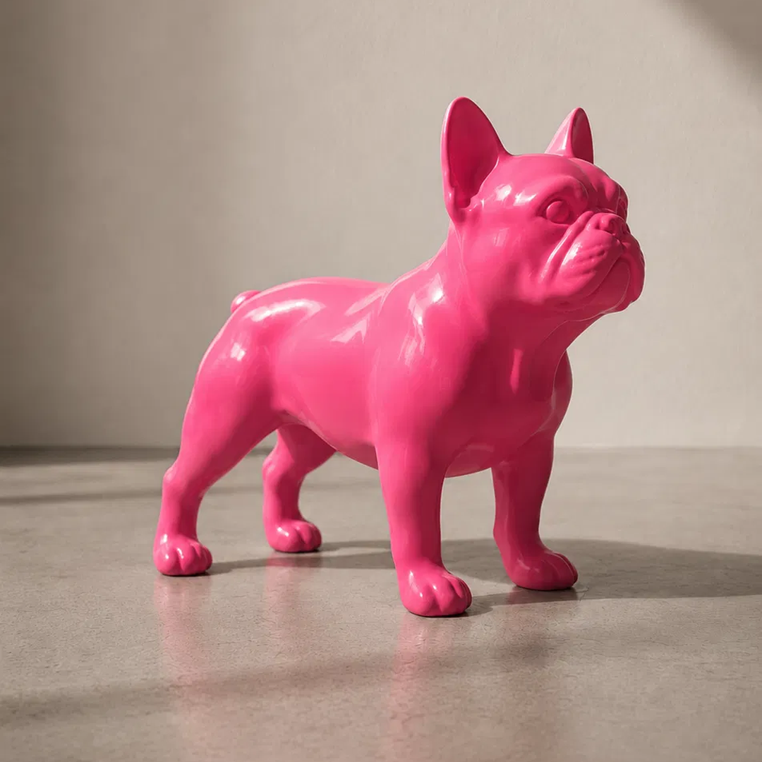 A glossy hot pink dog figurine, shaped like a French Bulldog, standing on a neutral gray surface against a beige background.